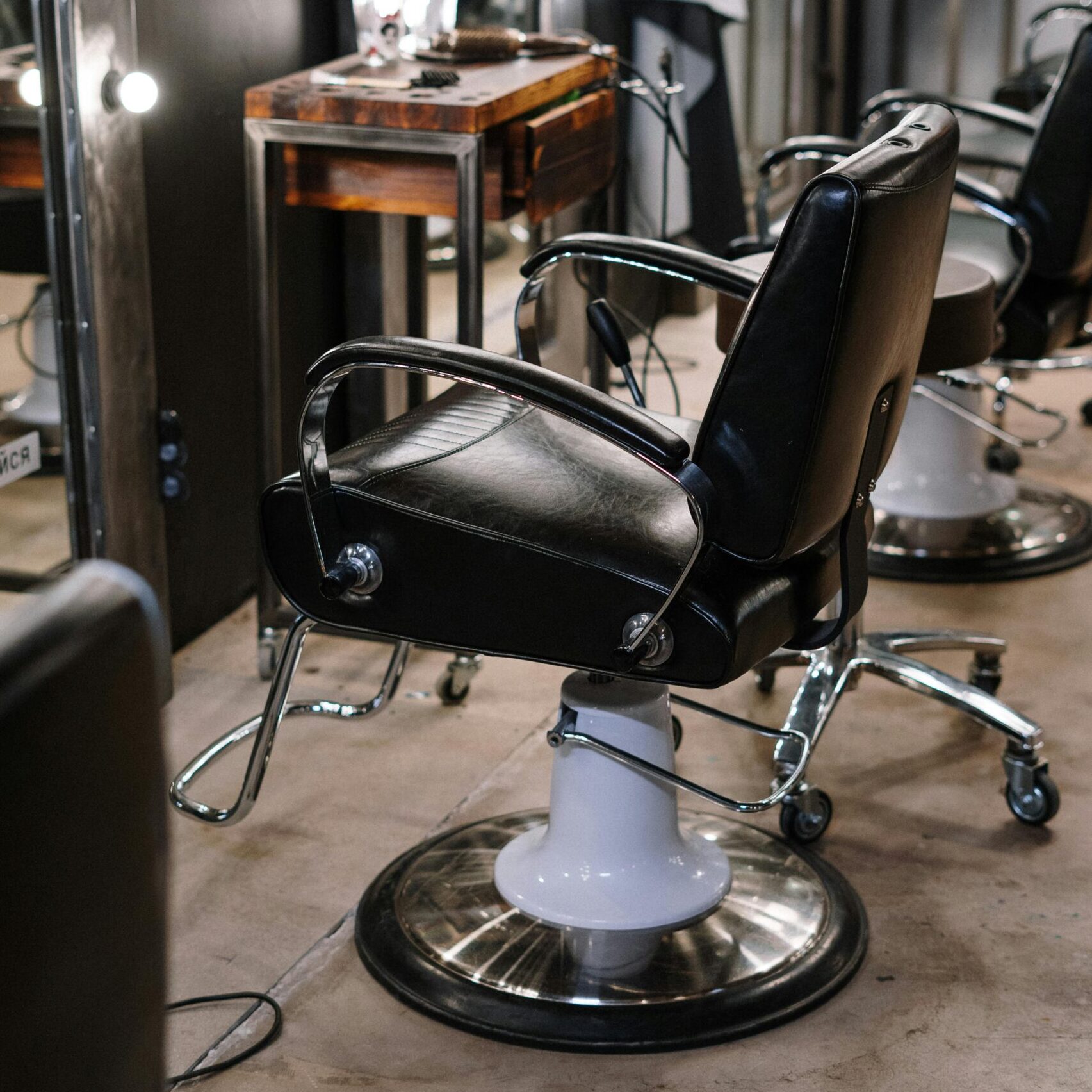 Empty barber shop with sleek chairs and illuminated mirrors.